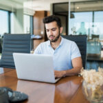 young male professional using technology at office